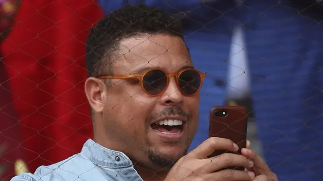 Ronaldo com o celular na mão e sorrindo. Foto: Julian Finney/Getty Images
