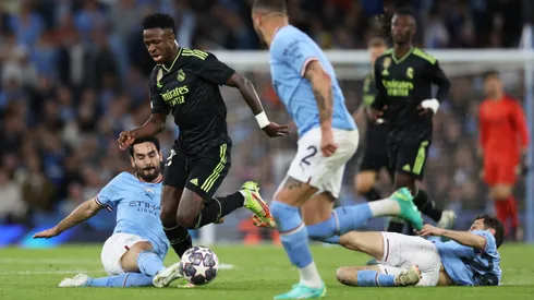 MANCHESTER, ENGLAND - MAY 17: Vinicius Junior of Real Madrid is challenged by Ilkay Guendogan of Manchester City during the UEFA Champions League semi-final second leg match between Manchester City FC and Real Madrid at Etihad Stadium on May 17, 2023 in Manchester, England. (Photo by Clive Brunskill/Getty Images)