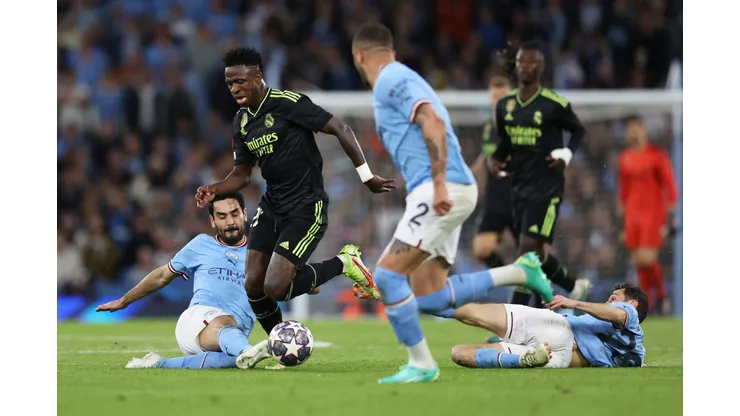 MANCHESTER, ENGLAND - MAY 17: Vinicius Junior of Real Madrid is challenged by Ilkay Guendogan of Manchester City during the UEFA Champions League semi-final second leg match between Manchester City FC and Real Madrid at Etihad Stadium on May 17, 2023 in Manchester, England. (Photo by Clive Brunskill/Getty Images)