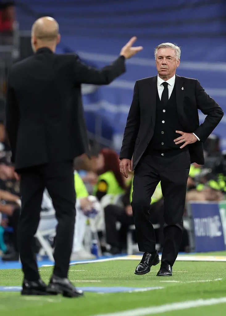 Guardiola gesticula enquanto Ancelotti acompanha a cena em segundo plano. Foto: Julian Finney/Getty Images