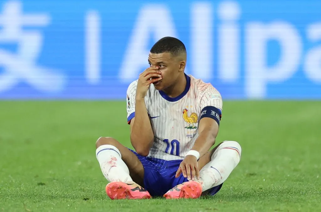 Mbappé no gramado após sofrer choque no nariz. (Photo by Kevin C. Cox/Getty Images)