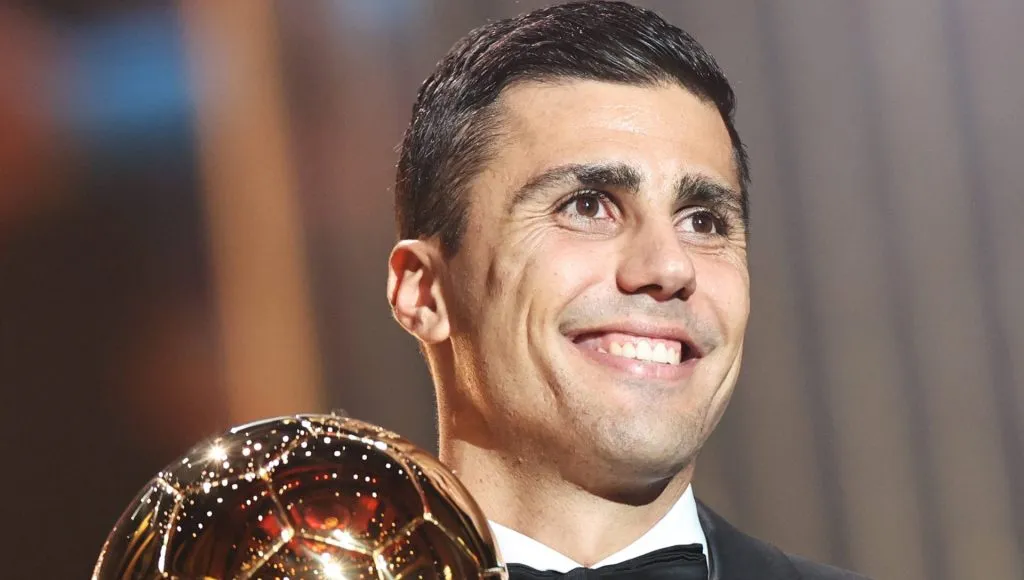 Rodri sorri para os fotógrafos com prêmio dourado na mão. Foto: IMAGO/Xinhua