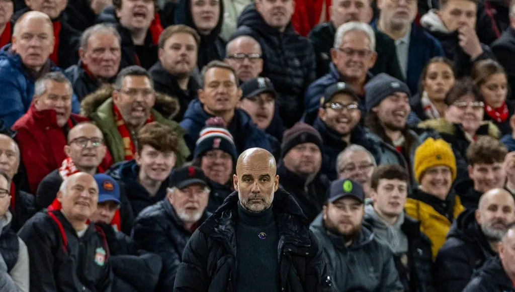Guardiola em pé na área técnica e atrás a torcida do Liverpool (IMAGO / Propaganda Photo)