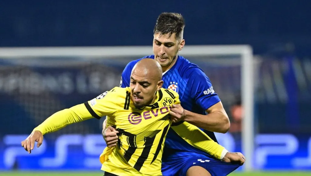 Malen tentando se desmarcar de Raul Torrente em jogo do Borussia Dortmund (IMAGO / HANZA MEDIA)