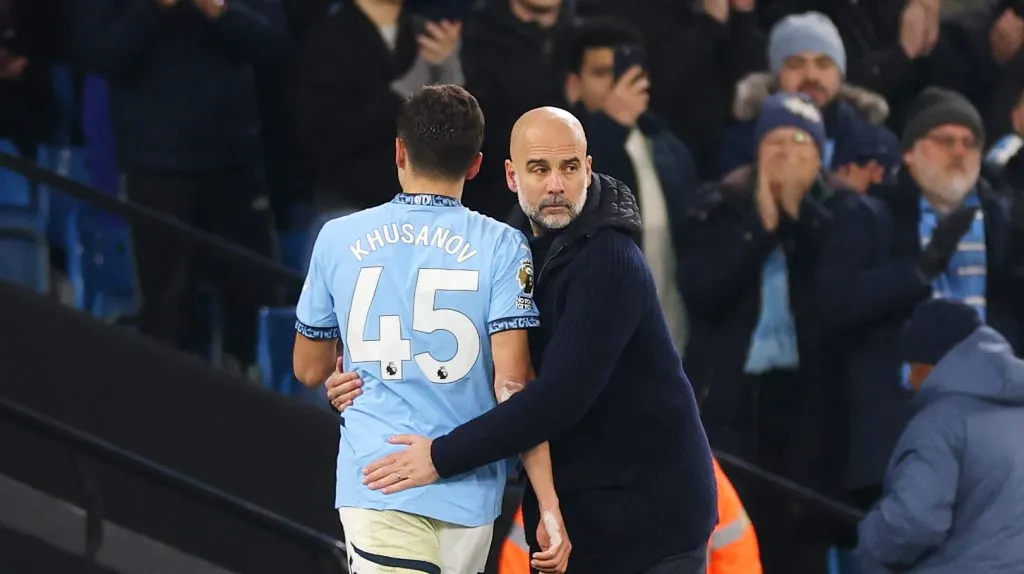 Khusanov sendo cumprimentado por Pep Guardiola (Carl Recine/Getty Images)