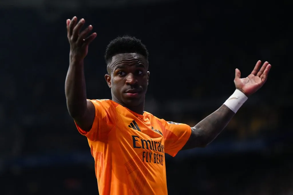 Vini Jr. com as mãos para cima em campo