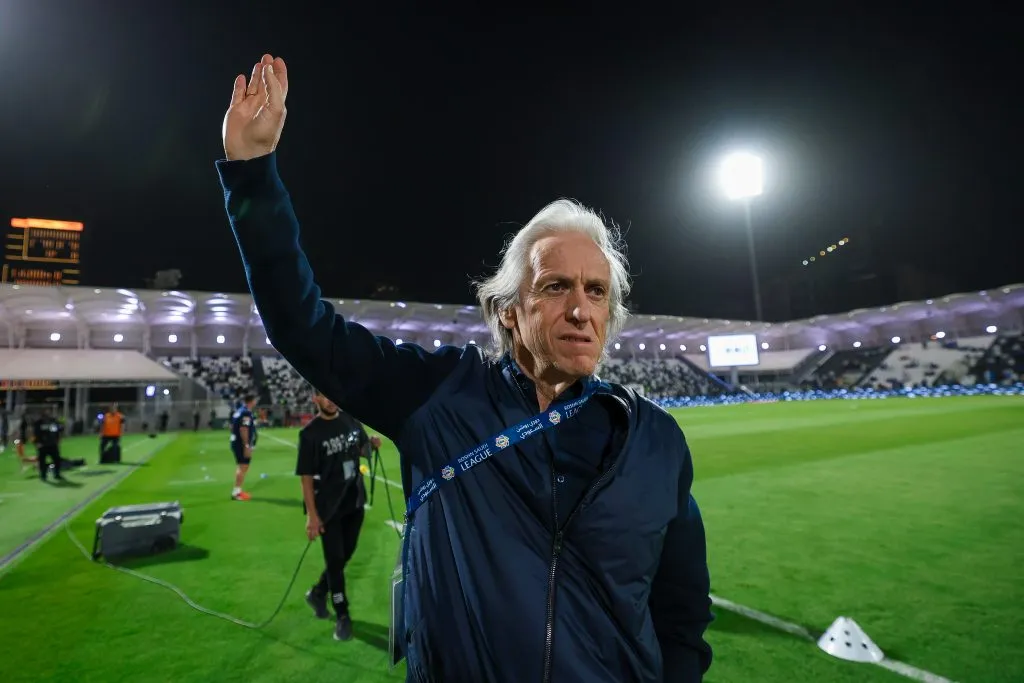 Jorge Jesus, grande alvo da Seleção Brasileira, acena com a mão, em campo, de jaqueta azul marinho. (Photo by Yasser Bakhsh/Getty Images)