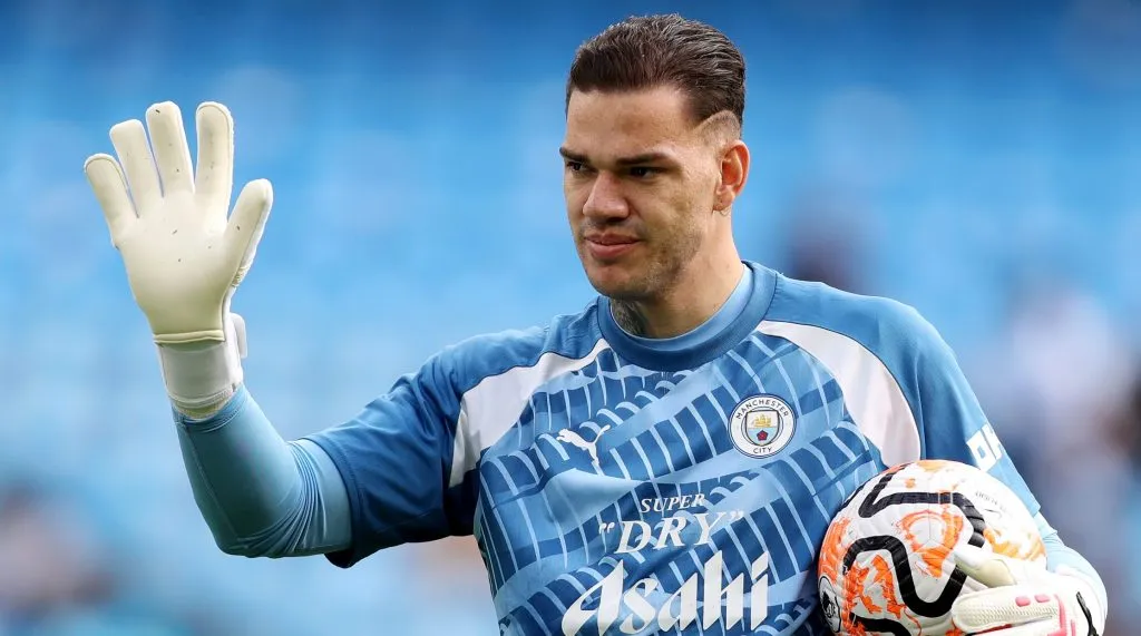 Ederson, com a camisa azul do Manchester City, em campo. (Photo by Charlotte Tattersall/Getty Images)