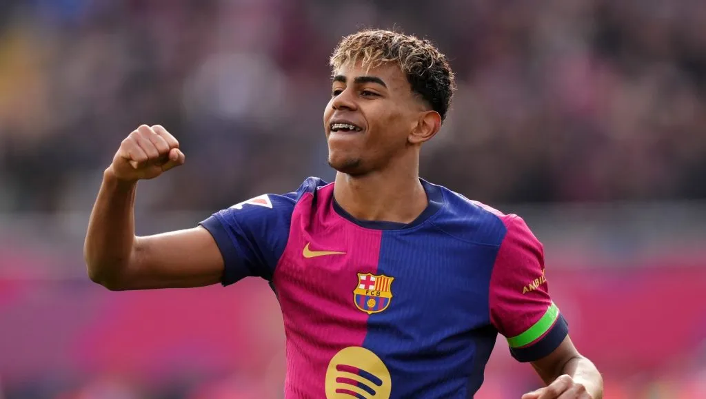 Lamine Yamal, em campo, com a camisa vinho e azul, do Barcelona (Photo by Alex Caparros/Getty Images)