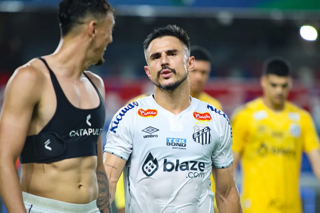 Willian Bigode, de camisa branca, com escudo do Santos 