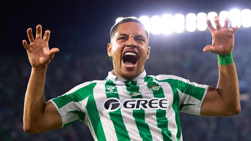 Vitor Roque, com as mãos levantadas, em campo, de camisa verde e branca, do Betis, mas é novo reforço do Palmeiras. (Photo by Fran Santiago/Getty Images)