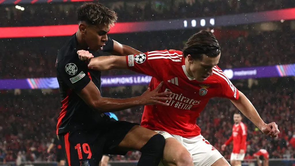 Lamine Yamal, do FC Barcelona, disputa a bola com Álvaro Carreras, do S.L. Benfica, durante a partida da 7ª rodada da fase de liga da UEFA Champions League 2024/25 entre SL Benfica e FC Barcelona, no Estádio do SL Benfica, em 21 de janeiro de 2025, em Lisboa, Portugal. (Foto de Carlos Rodrigues/Getty Images)