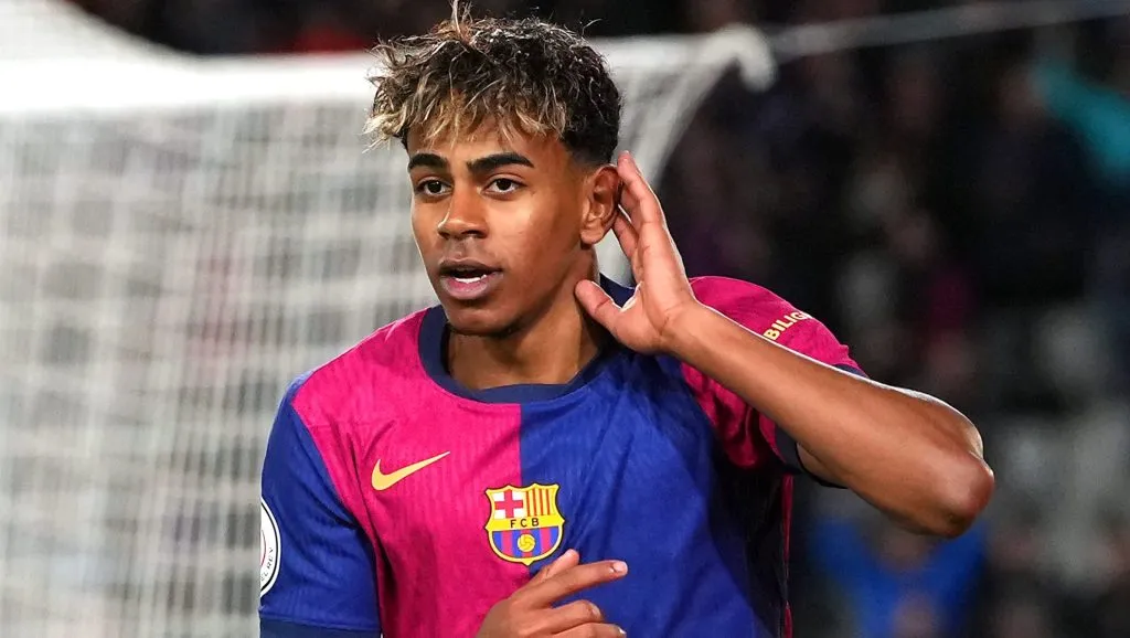 Lamine Yamal, em campo, pelo Barcelona, de camisa vermelha e azul. Lamine Yamal, atacante do Barcelona (Photo by Alex Caparros/Getty Images)