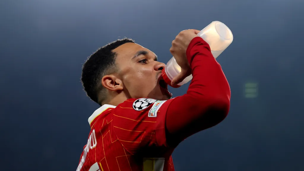 Trent Alexander-Arnold bebendo água em partida do Liverpool contra o PSG (Photo by Julian Finney/Getty Images)