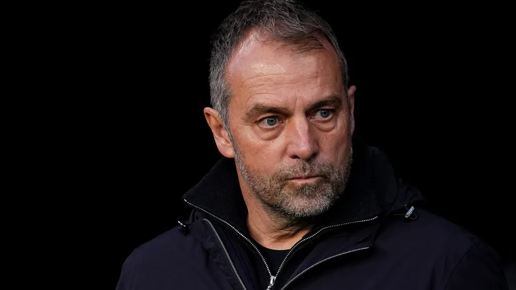 Hansi Flick, treinador do Barcelona, de jaqueta preta, em campo. (Photo by Aitor Alcalde/Getty Images)