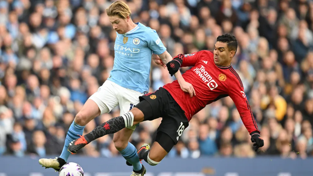 Kevin de Bruyne recebe carrinho de Casemiro em jogo pela Premier League (Photo by Michael Regan/Getty Images)