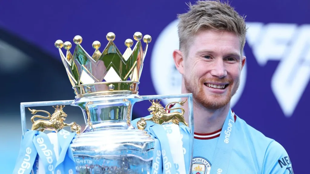 Kevin De Bruyne, segurando a taça, com a camisa azul do Manchester City. (Photo by Catherine Ivill/Getty Images)