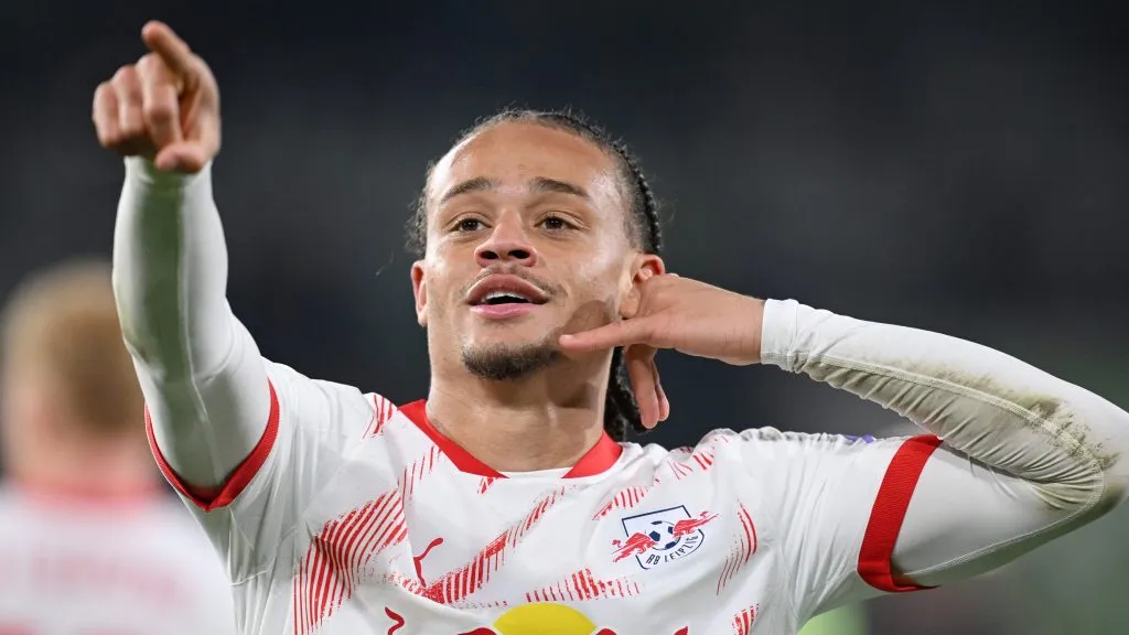 Xavi Simons, alvo do Manchester City, em campo, com a mão na orelha e de camisa branca com detalhes vermelhos. (Photo by Stuart Franklin/Getty Images)