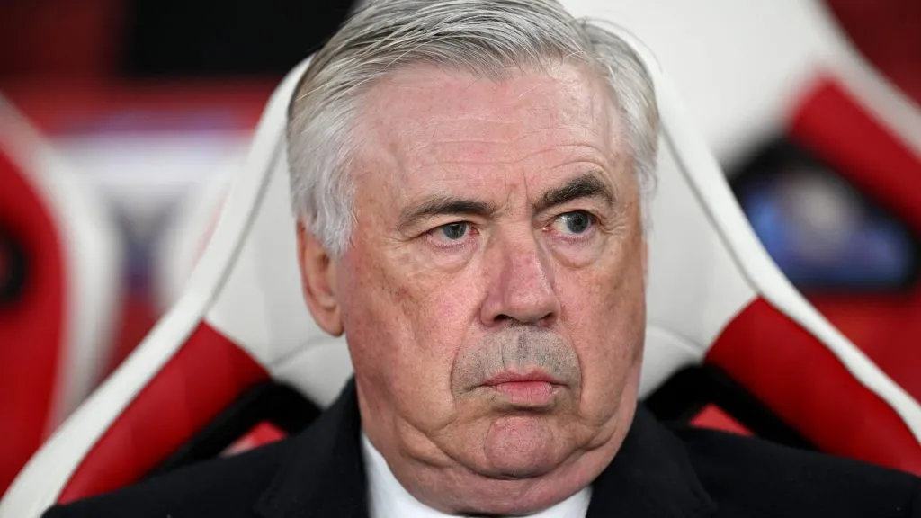 Ancelotti, sentado no banco de reservas, de terno preto, no Real Madrid (Photo by Justin Setterfield/Getty Images)