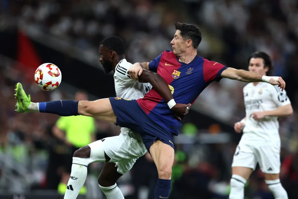 Robert Lewandowski, do FC Barcelona, disputa a posse de bola com Antonio Rüdiger, do Real Madrid (encoberto), durante a final da Supercopa da Espanha entre Real Madrid e FC Barcelona, na King Abdullah Sports City, em 12 de janeiro de 2025, em Jeddah, Arábia Saudita. (Foto de Yasser Bakhsh/Getty Images)