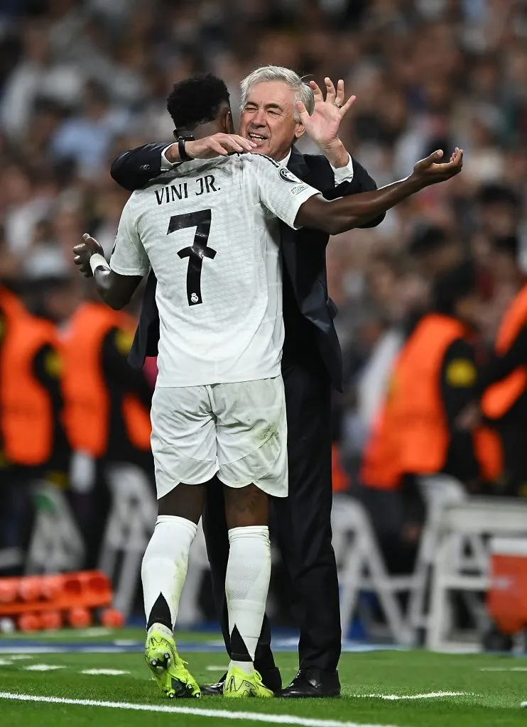 Vini Jr, da Seleção Brasileira e Real Madrid, com a camisa branca e Ancelotti, de terno preto