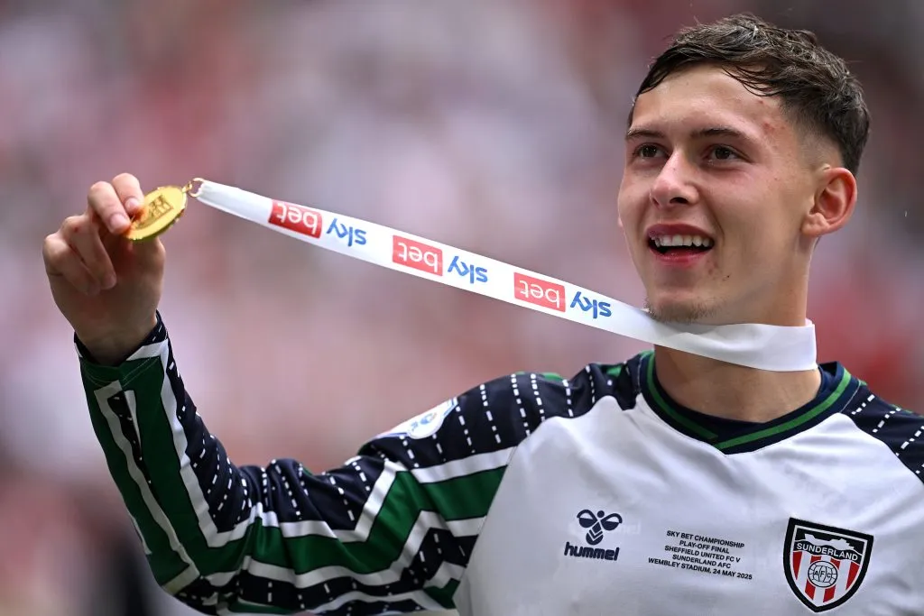 Alvo do Liverpool, Chris Rigg, de camisa branca com detalhes azuis e verdes 