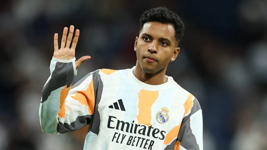 Rodrygo, em campo, com a camisa branca, laranja e cinza