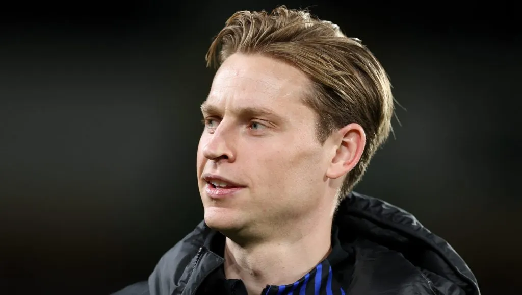 De Jong, com a jaqueta preta e camsa azul, em campo