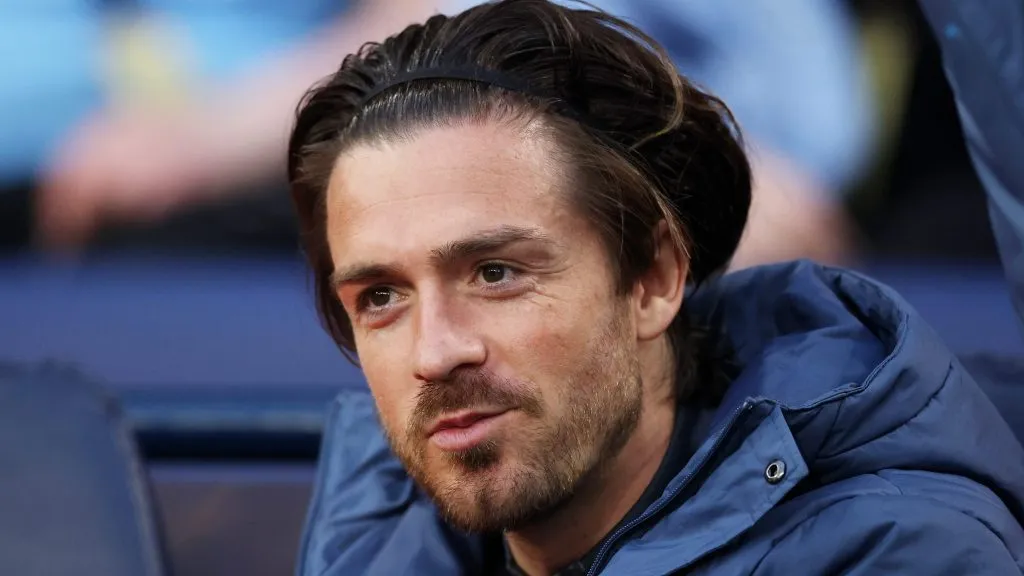 Jack Grealish, no banco de reservas, com a jaqueta azul