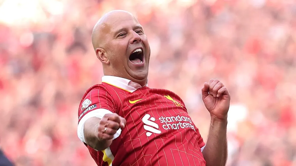 Arne Slot, em campo, comemora, com a camisa vermelha