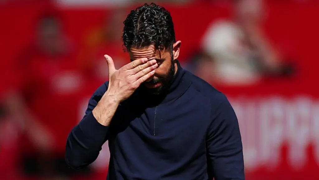 Amorim aparece em campo com camisa preta de manga comprida e cabeça baixa com a mão na testa. Foto: Marc Atkins/Getty Images