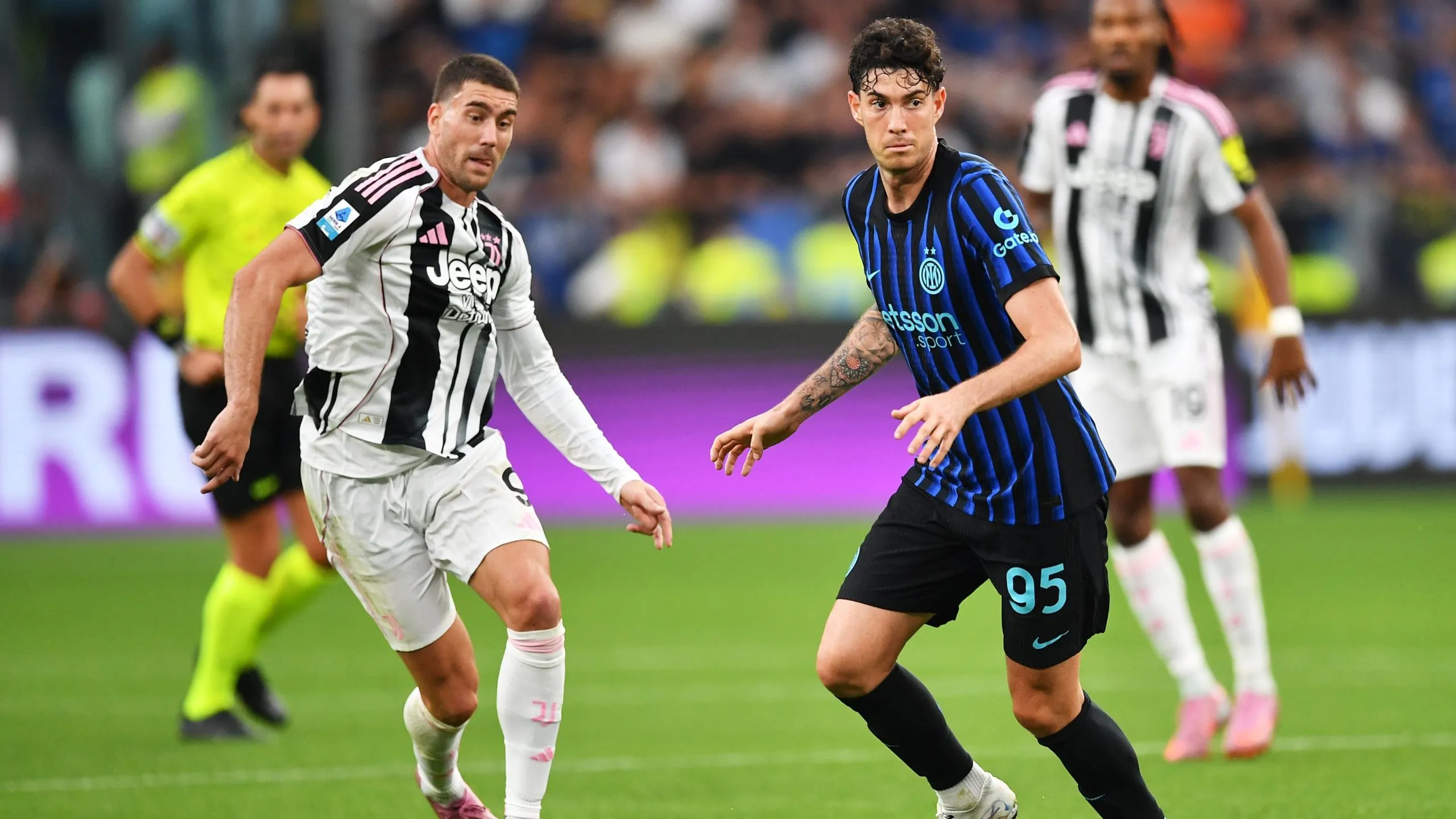 Alessandro Bastoni, da Internazionale, corre com a bola sob pressão de Dusan Vlahovic, da Juventus, durante a partida da Série A entre Juventus FC e FC Internazionale, em 13 de setembro de 2025, em Turim, Itália. Foto: Valerio Pennicino/Getty Images