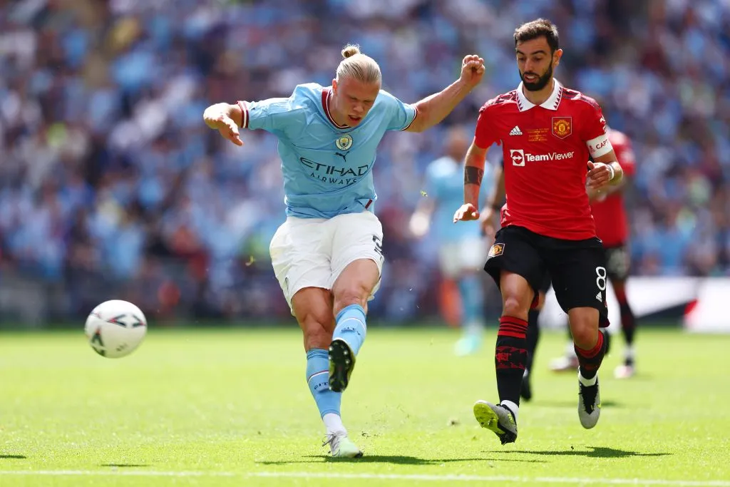 Erling Haaland, do Manchester City, chuta sob pressão de Bruno Fernandes, do Manchester United, durante a final da Emirates FA Cup entre Manchester City e Manchester United, no Estádio de Wembley, em 3 de junho de 2023, em Londres, Inglaterra. Foto: Clive Rose/Getty Images