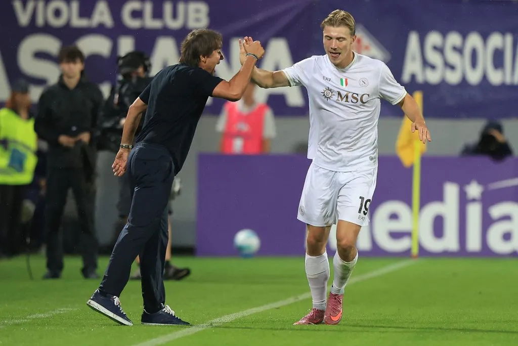 Hojlund tocando a mão de Conte com a camisa branca do Napoli em campo (Photo by Gabriele Maltinti/Getty Images)