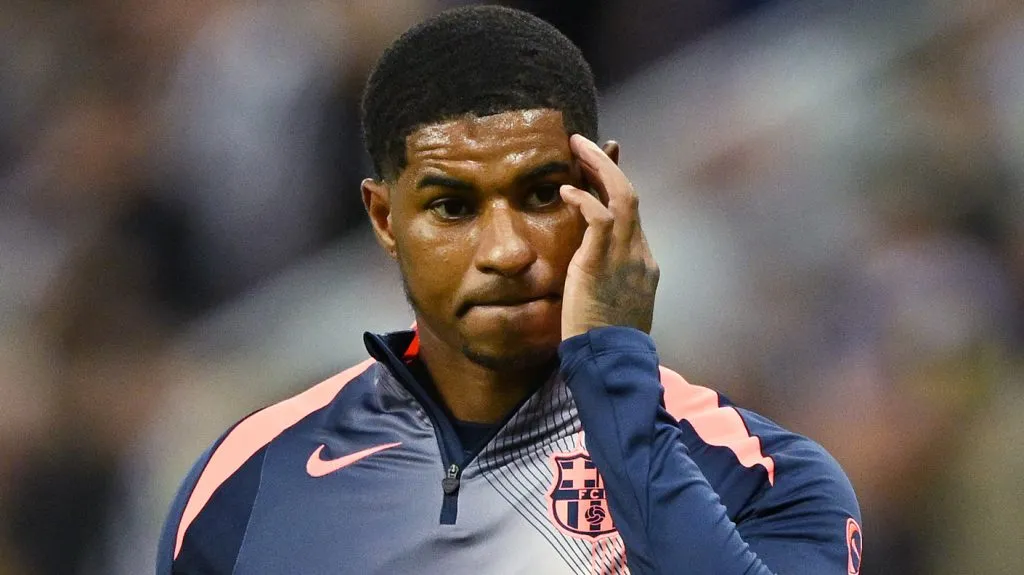 Rashford, de camisa cinza e laranja, em campo