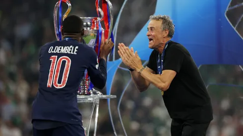 Ousmane Dembélé, do Paris Saint-Germain, beija o troféu da Liga dos Campeões da UEFA, enquanto Luis Enrique, técnico do Paris Saint-Germain, comemora após a vitória da equipe, garantindo ao Paris Saint-Germain o primeiro título da Liga dos Campeões da UEFA na história do clube e um recorde de vitórias na final da Liga dos Campeões da UEFA, com placar de 5 a 0, após a final da Liga dos Campeões da UEFA de 2025 entre Paris Saint-Germain e FC Internazionale Milano na Munich Football Arena em 31 de maio de 2025 em Munique, Alemanha. Foto: Carl Recine/Getty Images