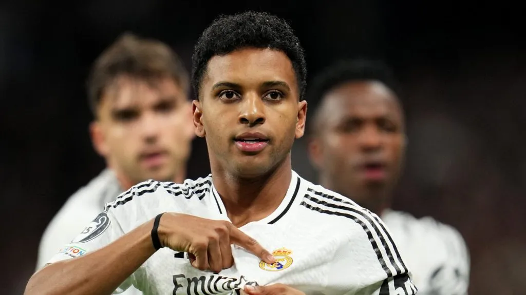 Rodrygo, com a mão no escudo do Real MADRID, na camisa branca