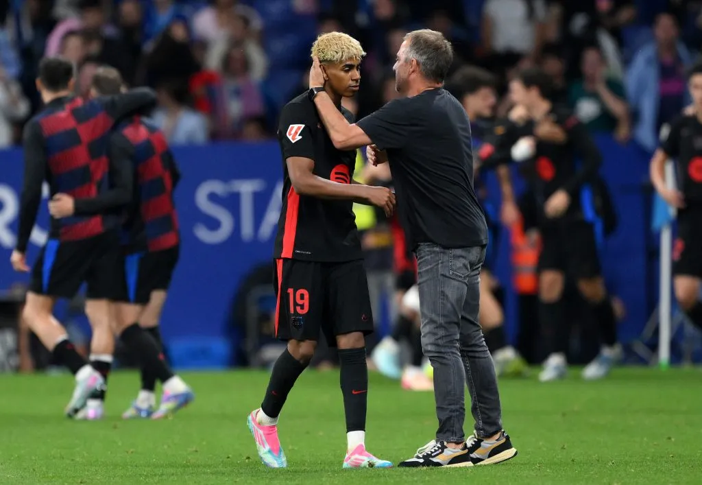 Lamine Yamal e Hansi Flick, pelo Barcelona. Segundo os portais El Nacional e Culémania, o treinador teria punido  jovem por atraso em um pré-jogo, mas Deco, diretor do clube, tirou a punição. (Foto: David Ramos/Getty Images)