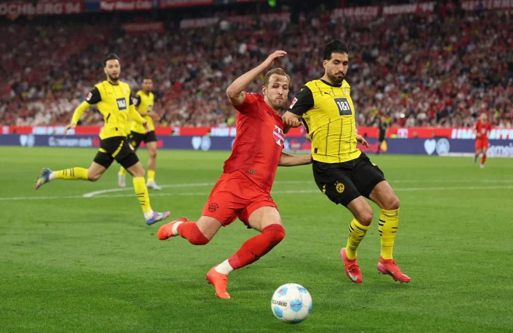 Harry Kane e Bensebaini em disputa de bola no jogo entre Bayern de Munique e Borussia Dortmund – Foto: Adam Pretty/Getty Images