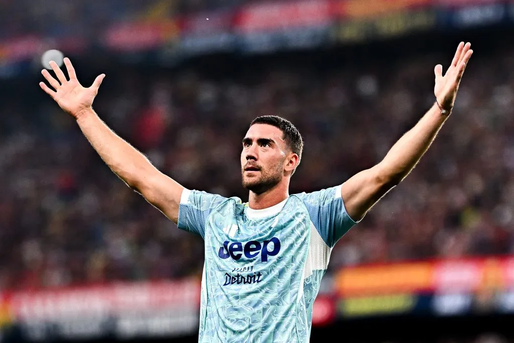 Dusan Vlahovic vestindo uma camisa azul da Juventus e comemorando com os braços erguidos.Foto: Simone Arveda/Getty Images 