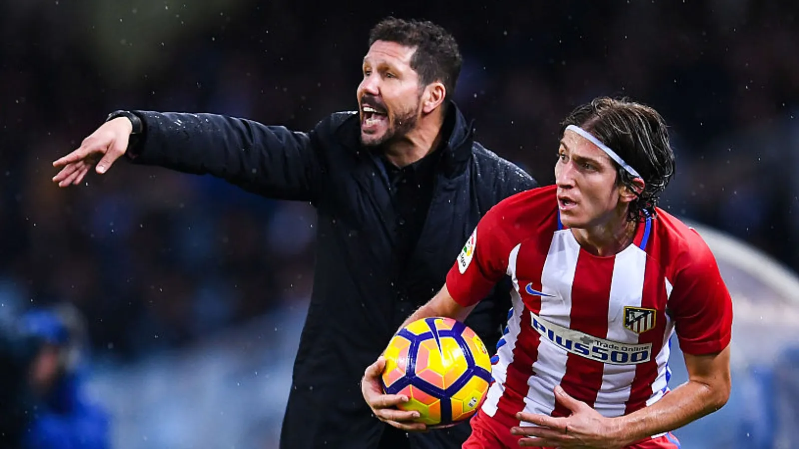 Diego Simeone dá instruçções a Filipe Luís, que segura a bola durante jogo.
