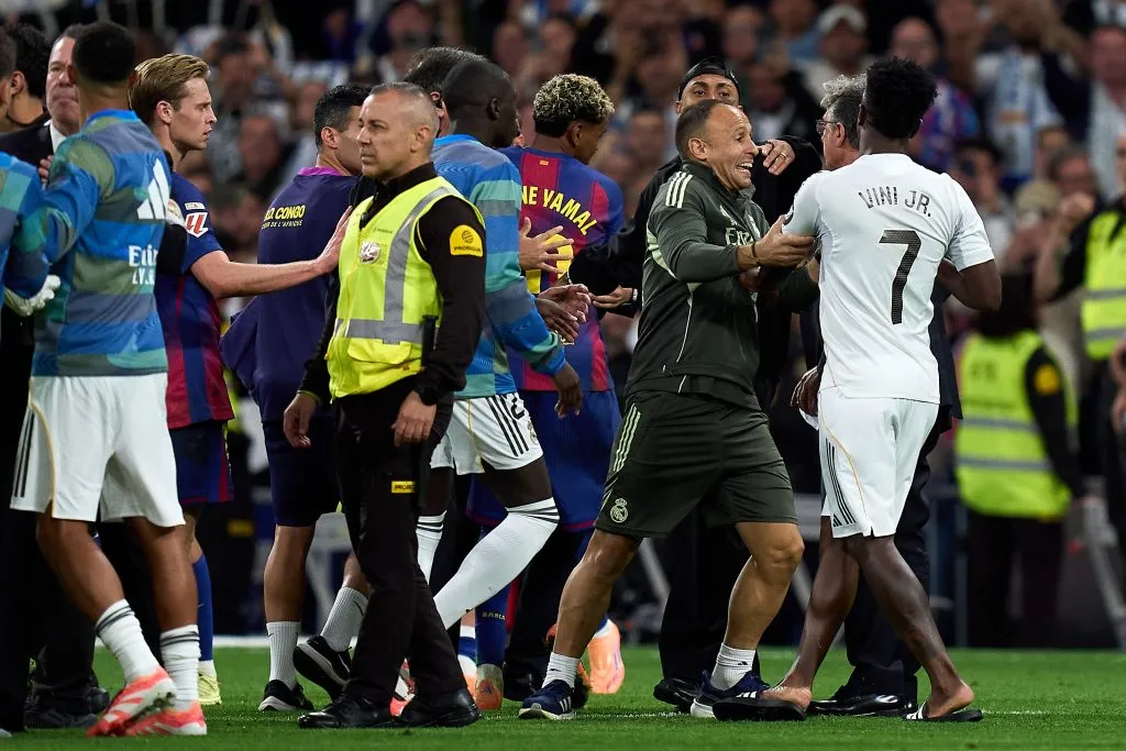 Vinicius Junior, do Real Madrid, é escoltado para fora do campo enquanto gesticula em direção a Lamine Yamal e Raphinha, do FC Barcelona, ​​que saem do campo após a partida da LaLiga EA Sports entre Real Madrid CF e FC Barcelona no Estádio Santiago Bernabeu, em 26 de outubro de 2025, em Madri, Espanha. (Foto de Angel Martinez/Getty Images)