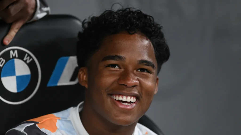Endrick sorri sentado no banco de reservas do Real Madrid. (Foto: Denis Doyle/Getty Images)