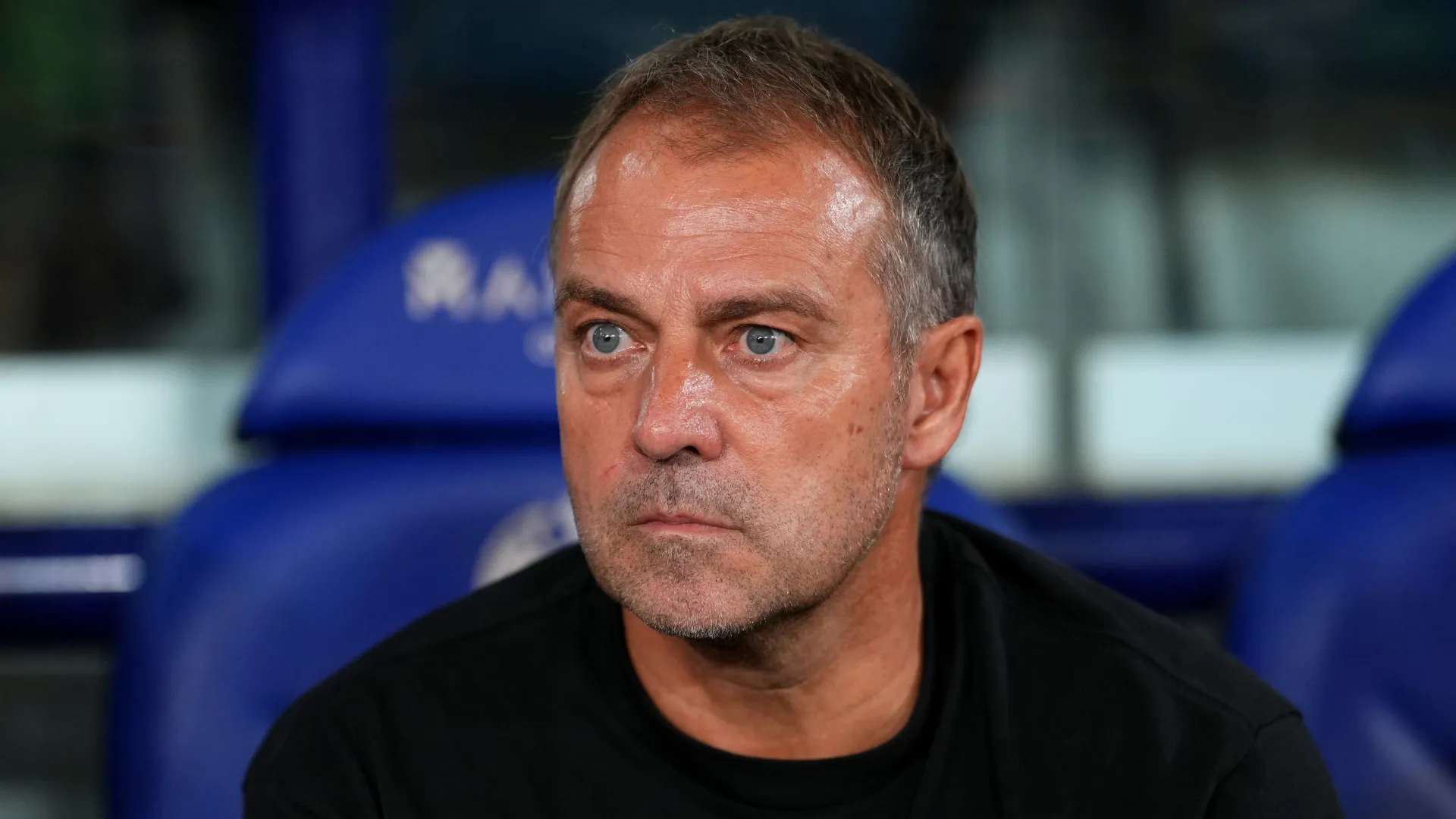 Hansi Flick sentado no banco de reservas durante partida do Barcelona