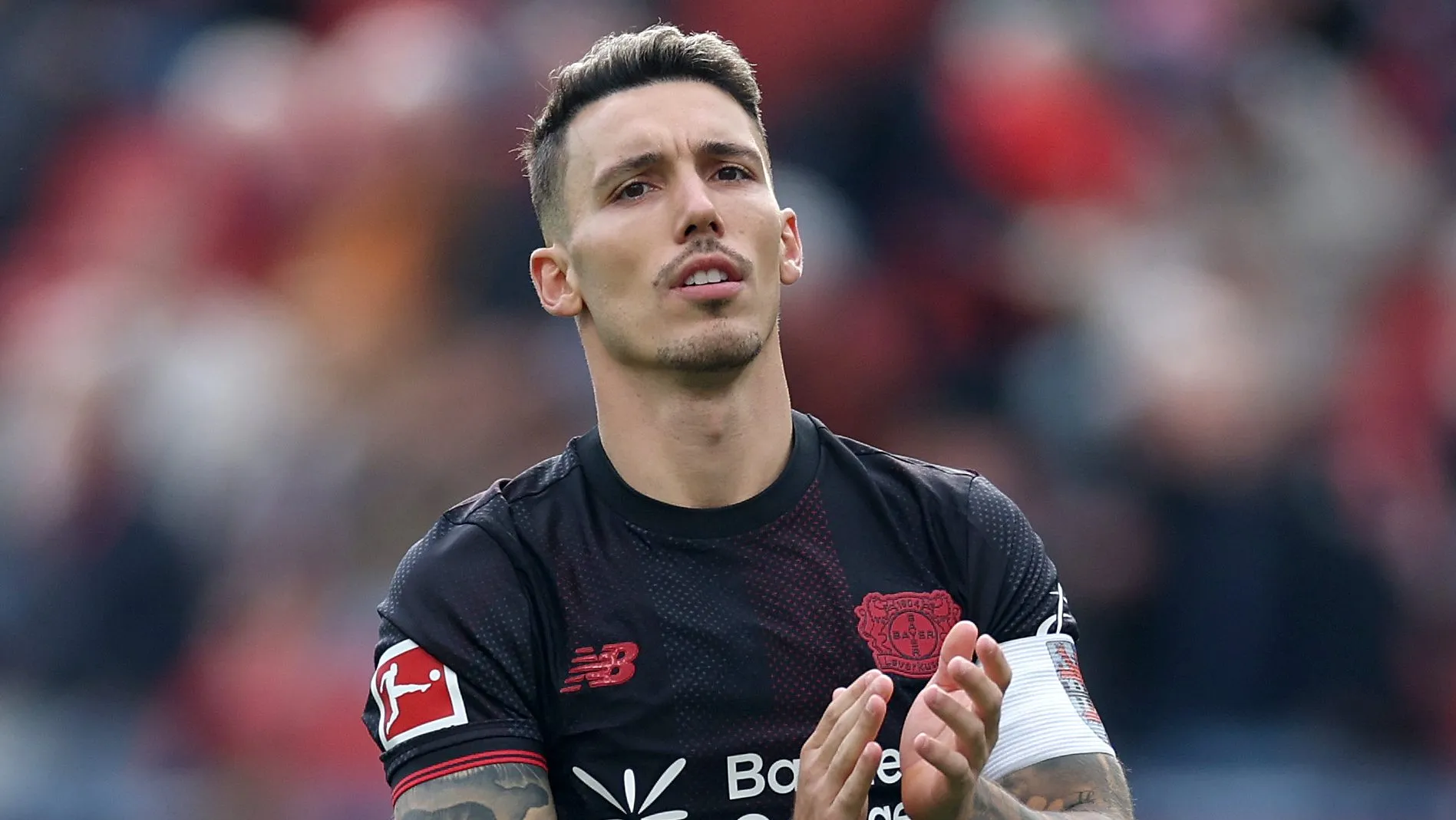 Álex Grimaldo,, em campo, com a camisa preta do Leverkusen