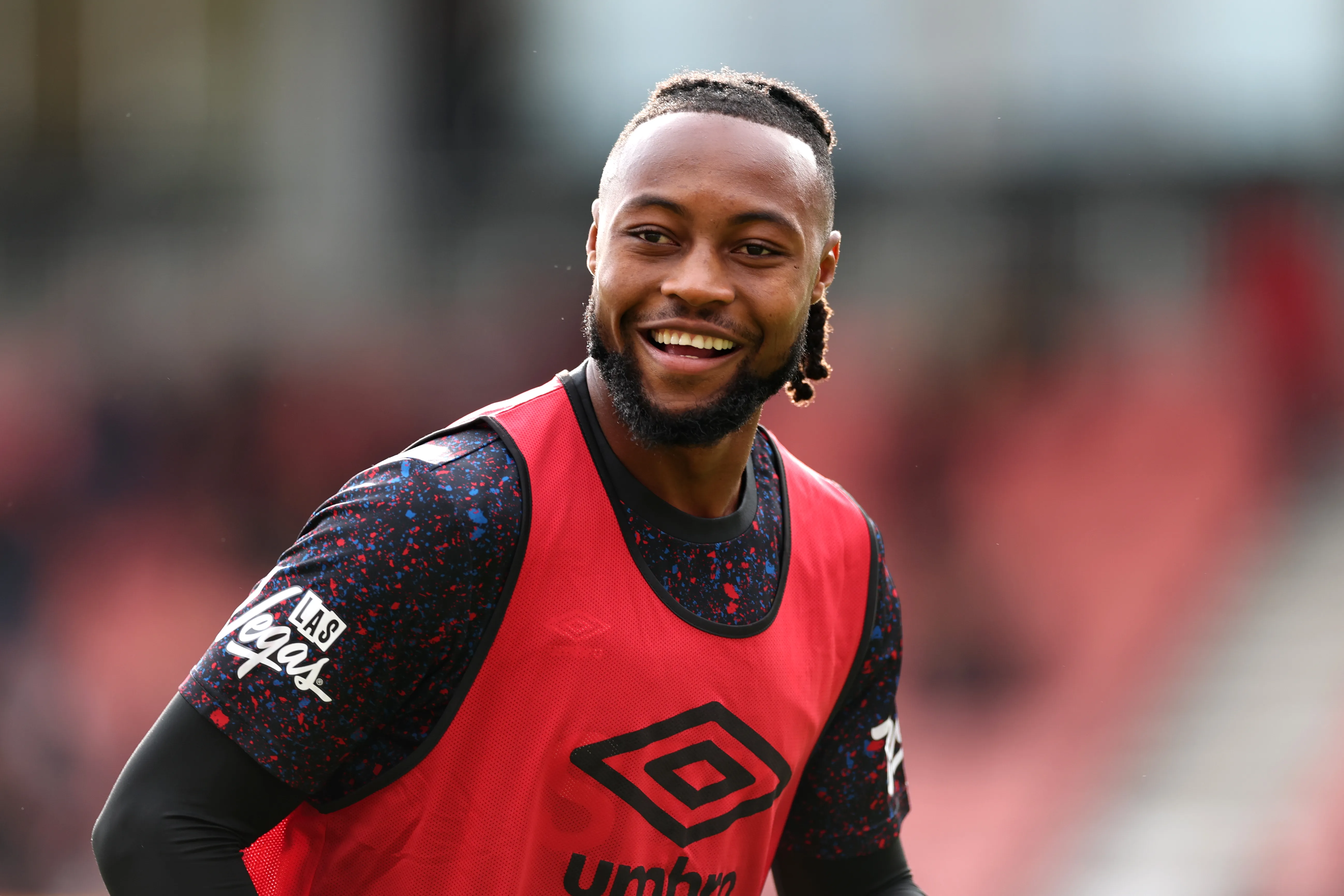 Semenyo sorridente vestindo um colete em cima da camisa do Bournemouth