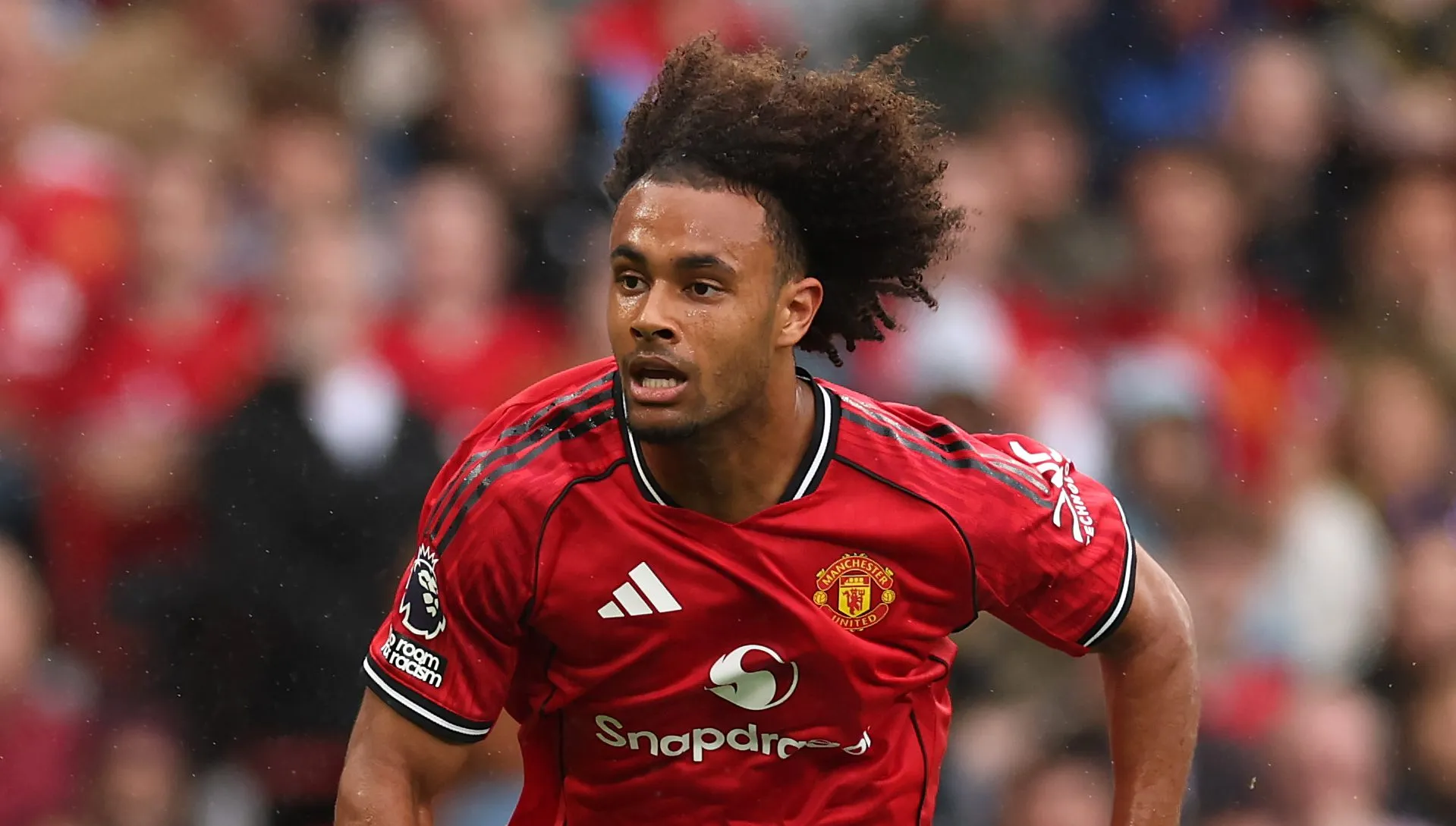 Zirkzee correndo com o uniforme tradicional do Manchester United