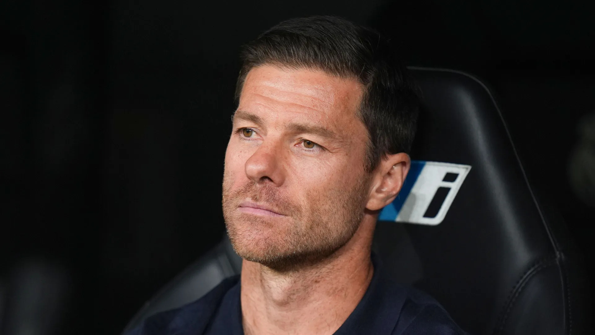 Xabi Alonso sentado no banco de reservas durante jogo do Real Madrid