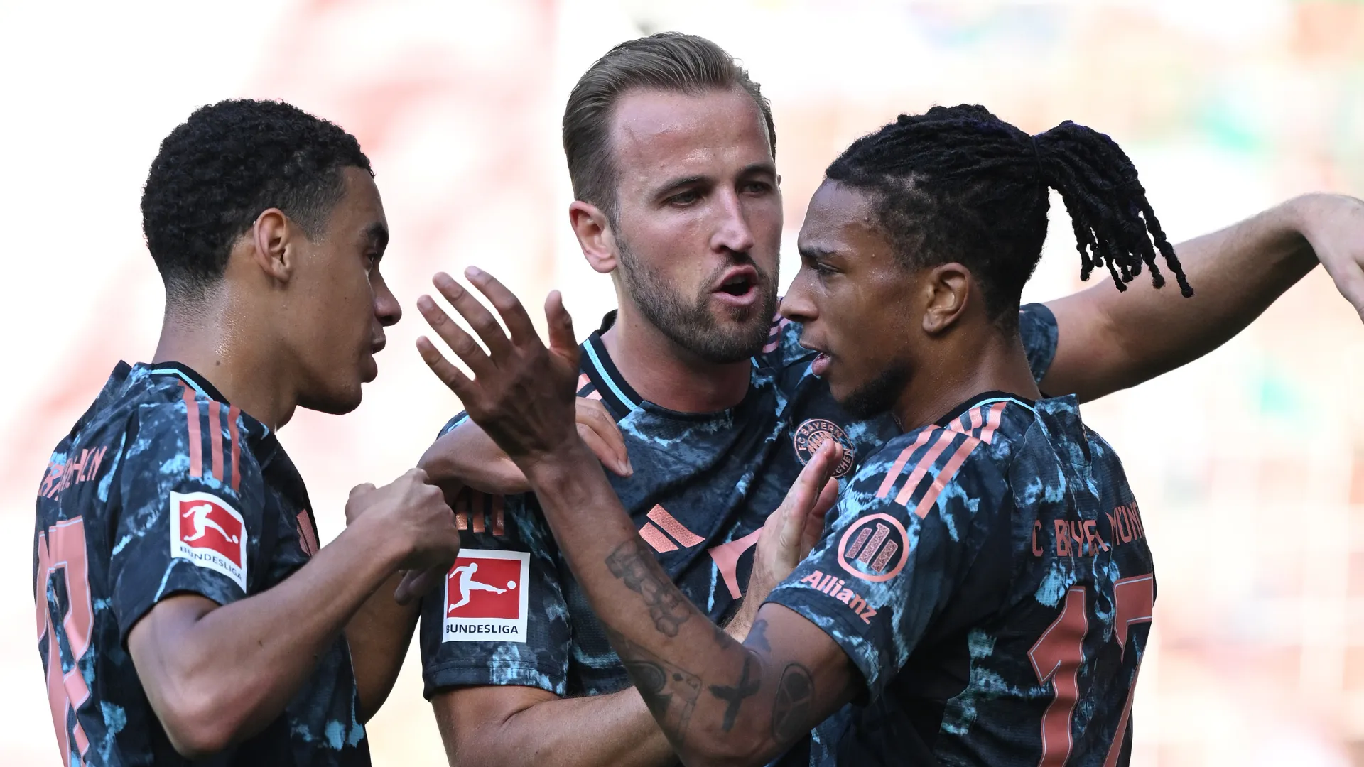 Olise, Jamal Musiala e Harry Kane comemorando gol com a camisa do Bayern de Munique