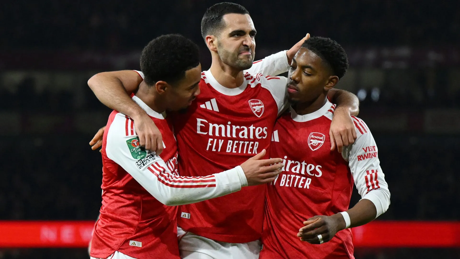 Ethan Nwaneri comemora gol com Mikel Merino e Myles Lewis-Skelly durante partida da Carabao Cup. Foto: Shaun Botterill/Getty Images)